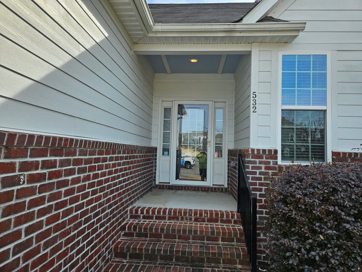 Clean brick-and-siding front entry of a Triangle home after soft washing